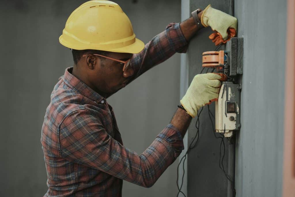 Electrical contractors working on a fuse board